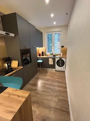 a kitchen with gray cabinets and a wooden floor at laurus's house in Rome
