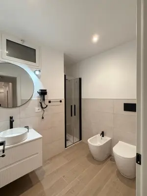 a bathroom with two sinks and a toilet and a mirror at Vita Lux Vatican Suites in Rome