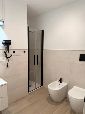 a bathroom with a shower and a sink and a toilet at Vita Lux Vatican Suites in Rome