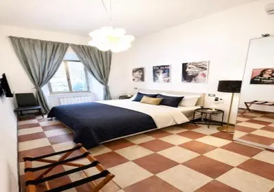 a bedroom with a bed and a checkered floor at Vatican Prestige Suite 