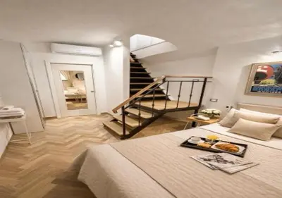 a bedroom with a large bed and a staircase at Vatican Prestige Suite 