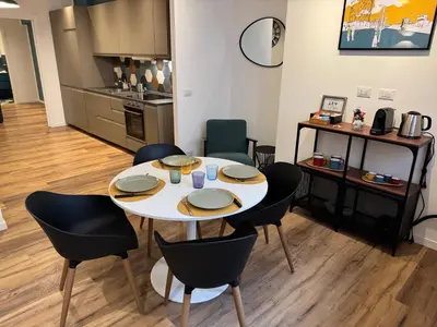 a table and chairs in a room with a kitchen at Luce suite trastevere in Rome