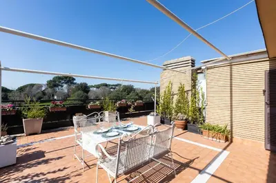 a patio with a table and chairs on a deck at San Pancrazio Penthouse by Rental in Rome in Rome