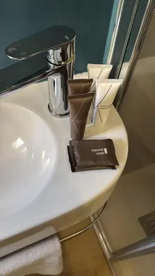 a bathroom sink with two cups on top of it at Rhome Vatican Chic in Rome