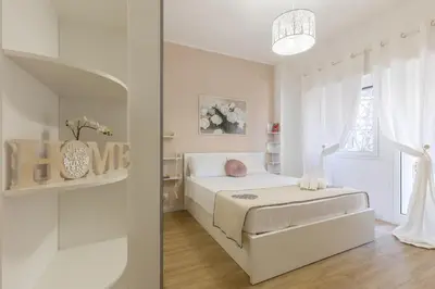 a white bedroom with a bed and a window at Roma Big terrace Home in Rome