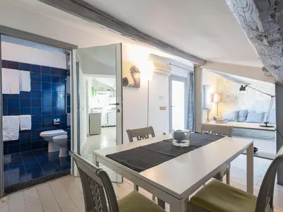 a dining room with a table and a bathroom at Central Rome Terrace Apartment in Rome