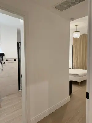 a room with a white wall and a bedroom at Vita Lux Vatican Suites in Rome