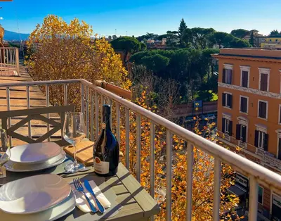 a table with a bottle of wine on a balcony at MARIA TERESA Apartment - Sophisticated Living and City Links - Quartiere TRIESTE in Rome