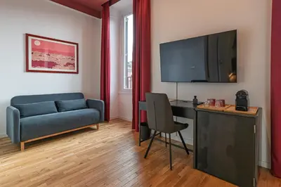 a living room with a couch and a desk with a television at EFFE 9 FLAMINIO Guest House in Rome-Vatican City in Rome