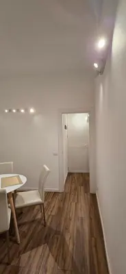 a room with a table and a chair and a hallway at Rooms And Comfort Apartment in Rome
