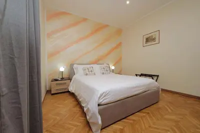 a bedroom with a bed and a wooden floor at Vatican Rooms Mura Aurelie in Rome