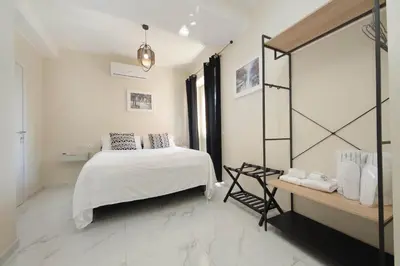 a white bedroom with a bed and a mirror at Vatican Rooms Mura Aurelie in Rome
