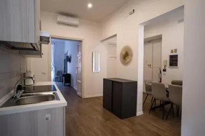 a kitchen and living room with a sink and a table at VT Cola di Rienzo Elegant Suites in Rome
