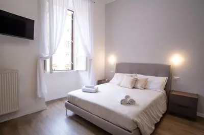 a bedroom with a white bed with towels on it at VT Cola di Rienzo Elegant Suites in Rome