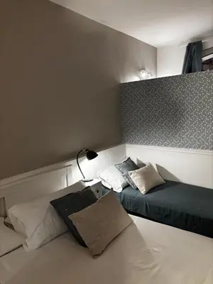 a small room with two beds and a lamp at The Hatters Inn in Rome