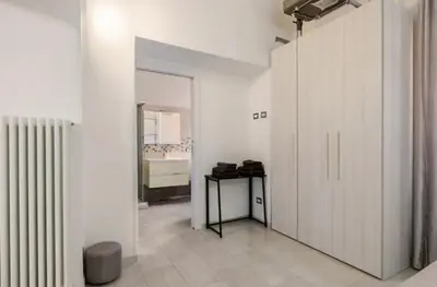 a room with white walls and a door and a table at La Casetta Sabelli In the center of Rome in Rome