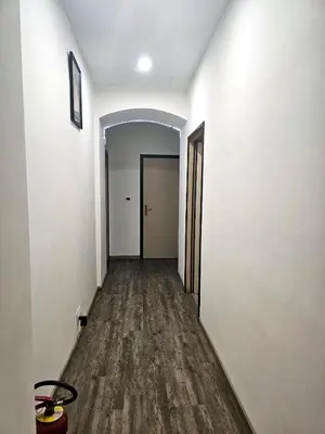 an empty hallway with white walls and wood floors at Cialdini 13 Roma in Rome