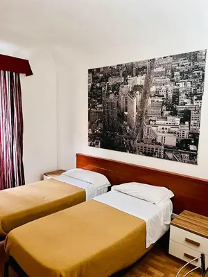 a hotel room with two beds and a desk at Beauty Holidays in Rome