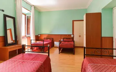 a hallway with a mirror and a vase with flowers in it at Ogbay Backpackers Haven in Rome