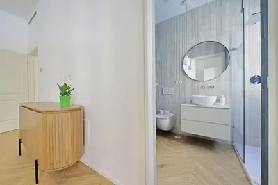 a bathroom with a toilet and a sink and a mirror at YCH-Spaceful apartment near Vatican in Rome