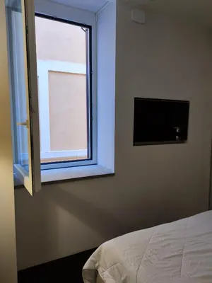 a bedroom with a window and a tv on the wall at Banchi Nuovi Ventuno in Rome