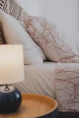 a bed with white pillows and a table with a lamp at Casetta in Rome
