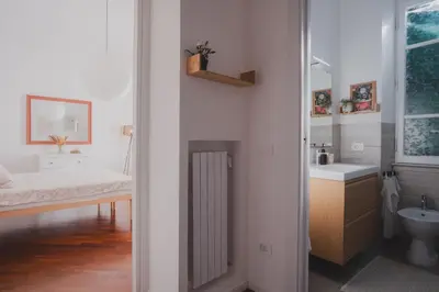 a white bathroom with a bed and a sink at Casetta in Rome