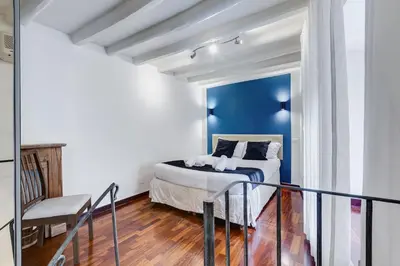 a bedroom with a bed and a blue wall at Vivilo Collection - Macelli Spanish Steps Apartment in Rome