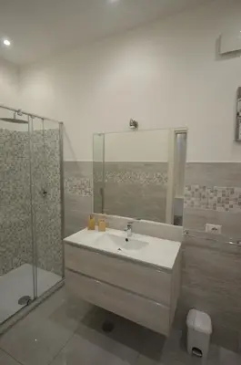 a bathroom with a sink and a shower at San Remo Apartment in Rome