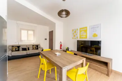 a living room with a wooden table and yellow chairs at Domus Citro, Cozy Flat in District Prenestina in Rome