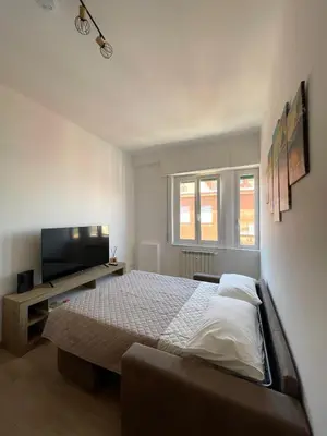 a bedroom with a bed and a flat screen tv at Numa House in Rome