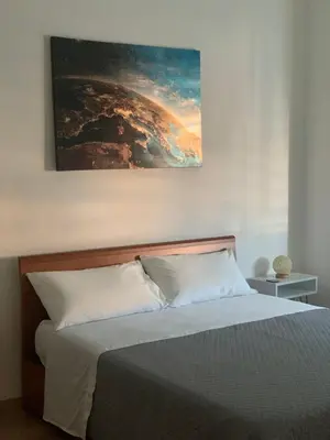 a bedroom with a bed with a painting on the wall at Numa House in Rome