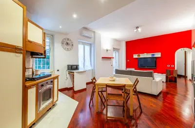 a kitchen and living room with a red wall at Vacanze Romane con giardino in Rome