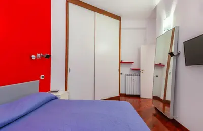a bedroom with a bed with a red wall at Vacanze Romane con giardino in Rome