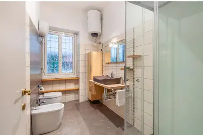 a bathroom with a toilet and a sink and a mirror at Vacanze Romane con giardino in Rome