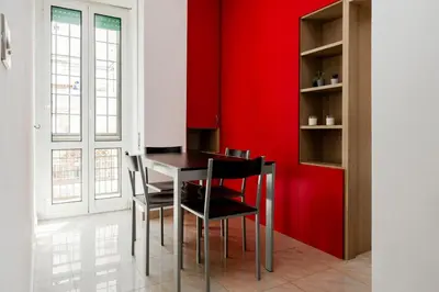 a dining room with red walls and a table and chairs at Maffis House in Rome