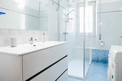 a white bathroom with a sink and a shower at Maffis House in Rome