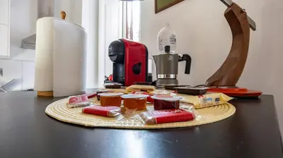a counter with a coffee maker and food on a table at Casa Maria Teresa by Rentbeat in Rome