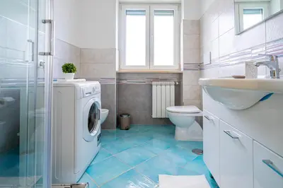 a bathroom with a washing machine and a sink at Domus Blu Aurelia in Rome