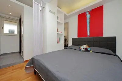 a bedroom with a large bed with a red painting on the wall at Manzoni in Rome