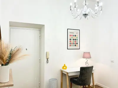 a white room with a desk and a chandelier at RomeAsYouLike-Esquilino Apartment N 86 in Rome