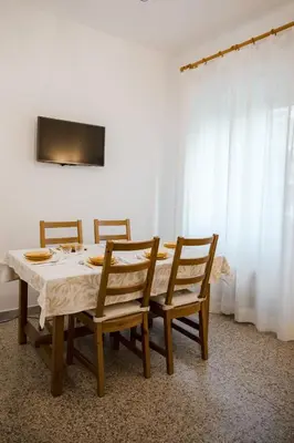 a dining room table with four chairs and a television at Domus Valle Aurelia - Vaticano - Metro Linea A in Rome