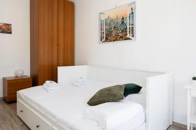 a white bed in a room with a picture on the wall at AnnaMarco Apartment in Rome