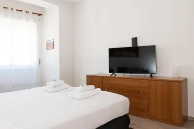 a bedroom with two beds and a flat screen tv at AnnaMarco Apartment in Rome