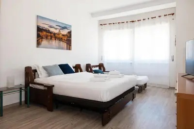a bedroom with two beds and a flat screen tv at AnnaMarco Apartment in Rome