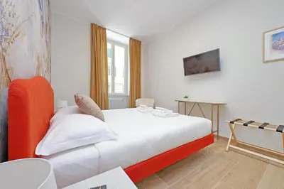 a bedroom with a white bed and a table at 4BNB - Stylish Spacious Apartment near Vatican in Rome