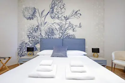 a bedroom with a large bed with blue and white wallpaper at 4BNB - Stylish Spacious Apartment near Vatican in Rome