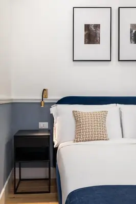a bedroom with a bed and a side table at Palomba Boutique Apartment in Rome