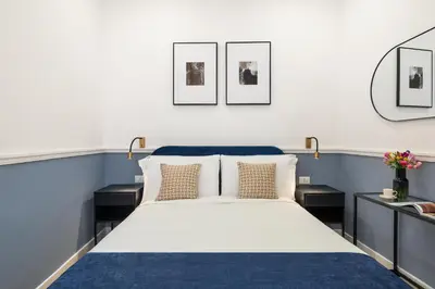 a bedroom with blue and white walls and a bed at Palomba Boutique Apartment in Rome
