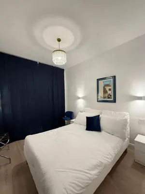 a bedroom with a large white bed with blue pillows at Vita Lux Vatican Suites in Rome